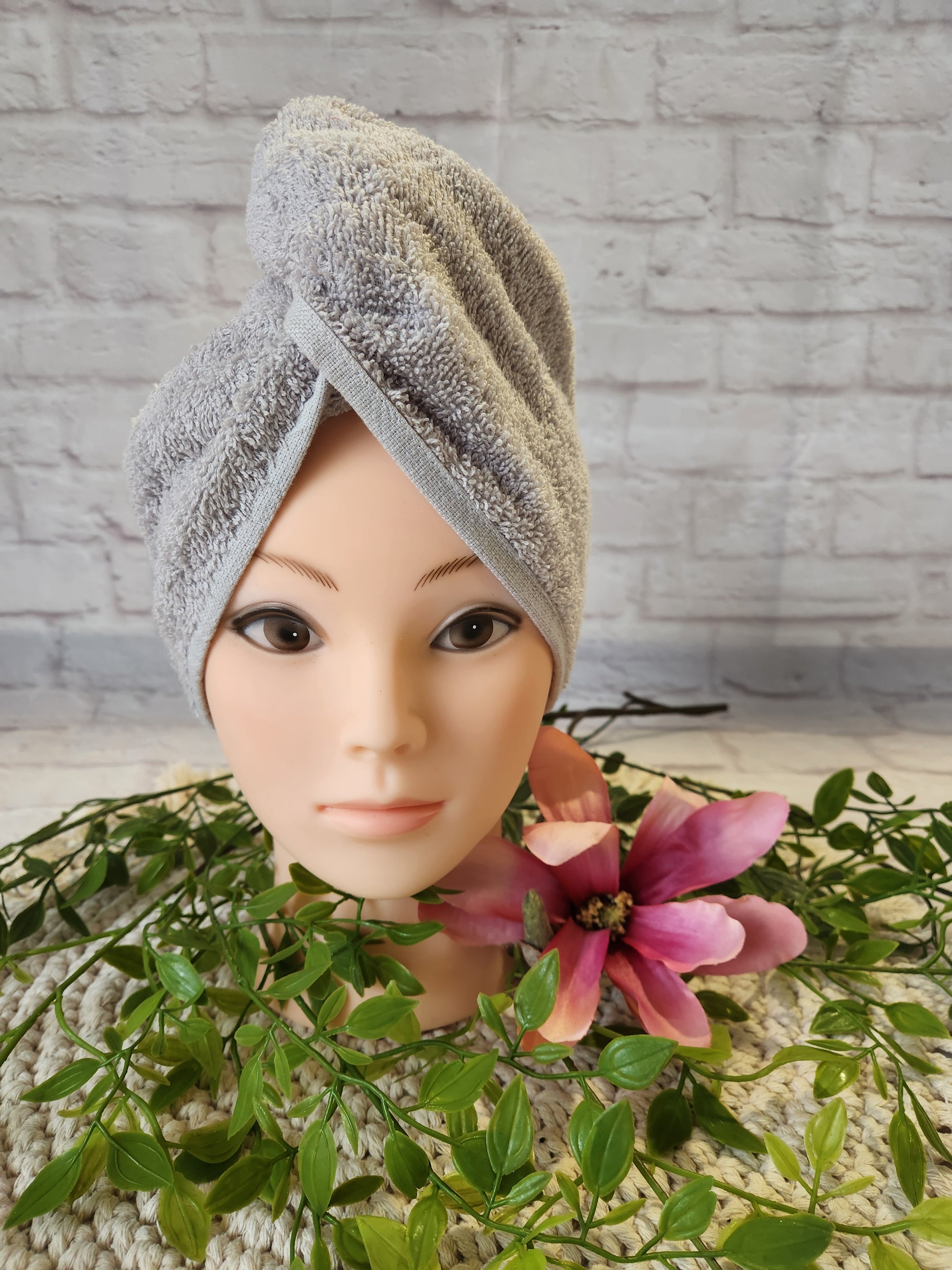 Turban Handtuch in hellgrau auf einem Schaufensterkopf in Frontalansicht