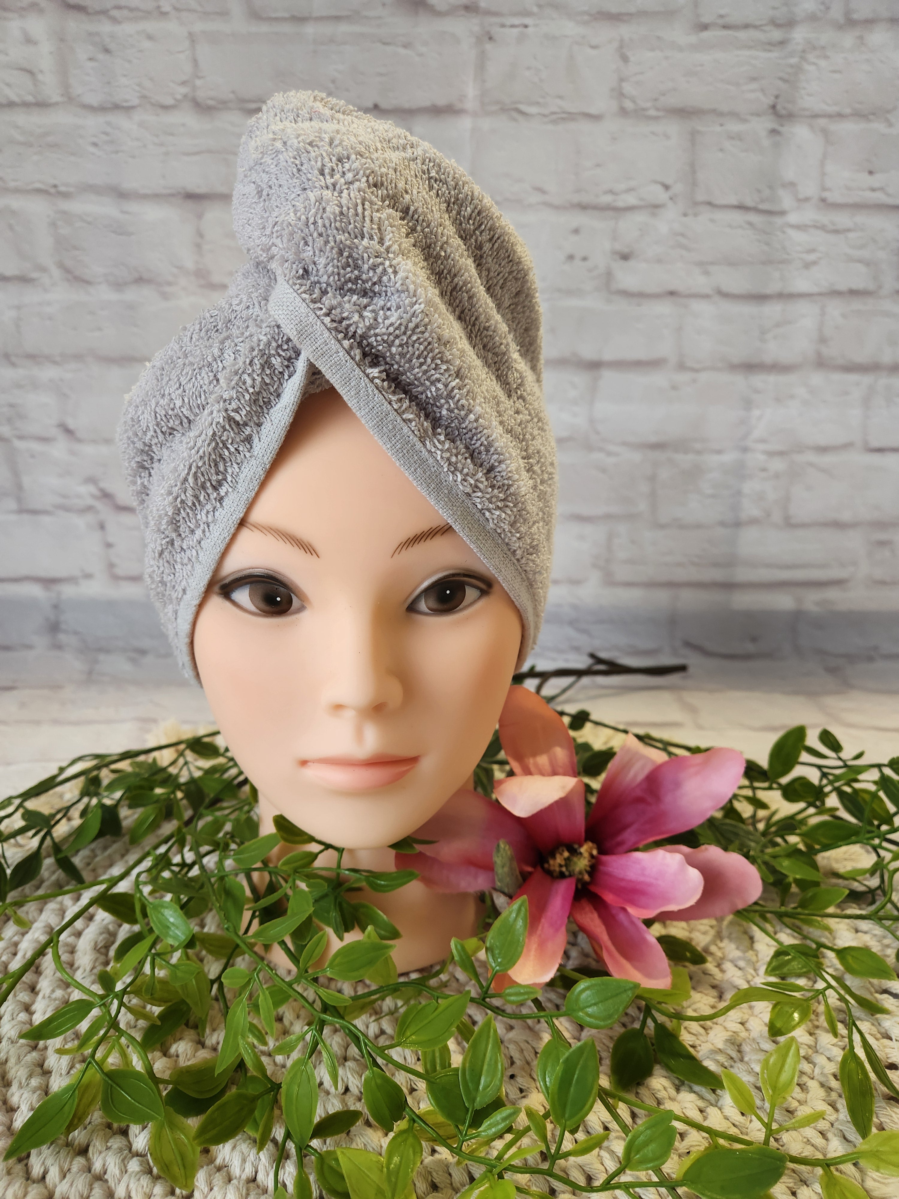 Turban Handtuch in hellgrau auf einem Schaufensterkopf in Frontalansicht